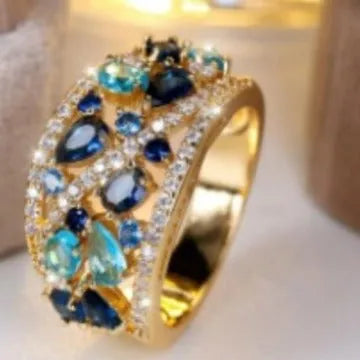 Women's hollow round fashion ring in gold or platinum with a choice of white or blue gemstone.