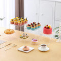 White plastic modular dessert display stand with six interlocking cubes for cake and pastry presentation