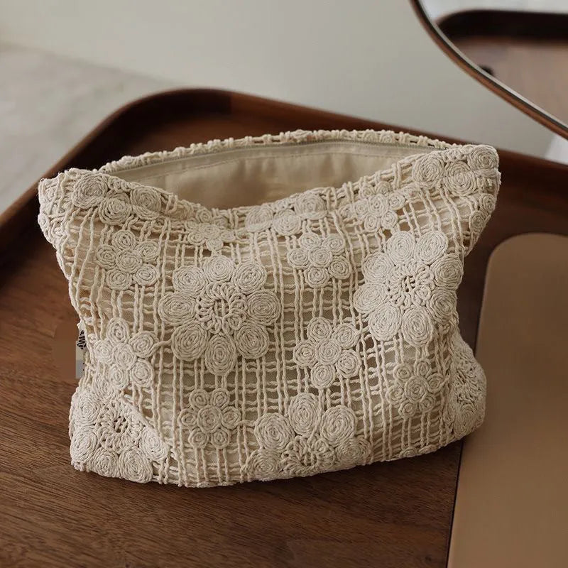 Handmade crocheted corduroy cosmetic bag with hollow flower cutouts and ethnic embroidery in a rope colour.