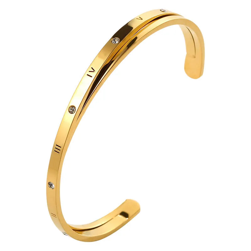 Open-ended stainless steel bracelet with zircon stones and love motif in electroplated gold finish