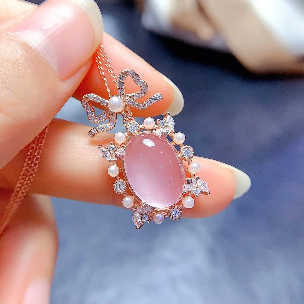 Geometric rose gold plated silver pendant with a pink rose quartz crystal on a necklace chain.