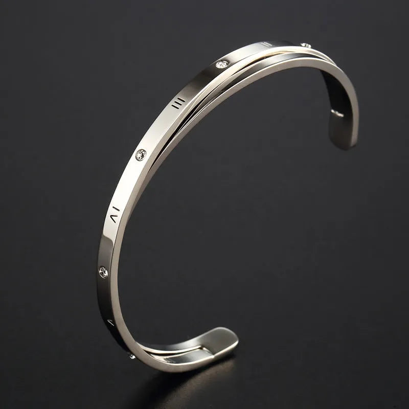 Open-ended stainless steel bracelet with zircon stones and love motif in electroplated gold finish