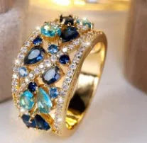 Women's hollow round fashion ring in gold or platinum with a choice of white or blue gemstone.