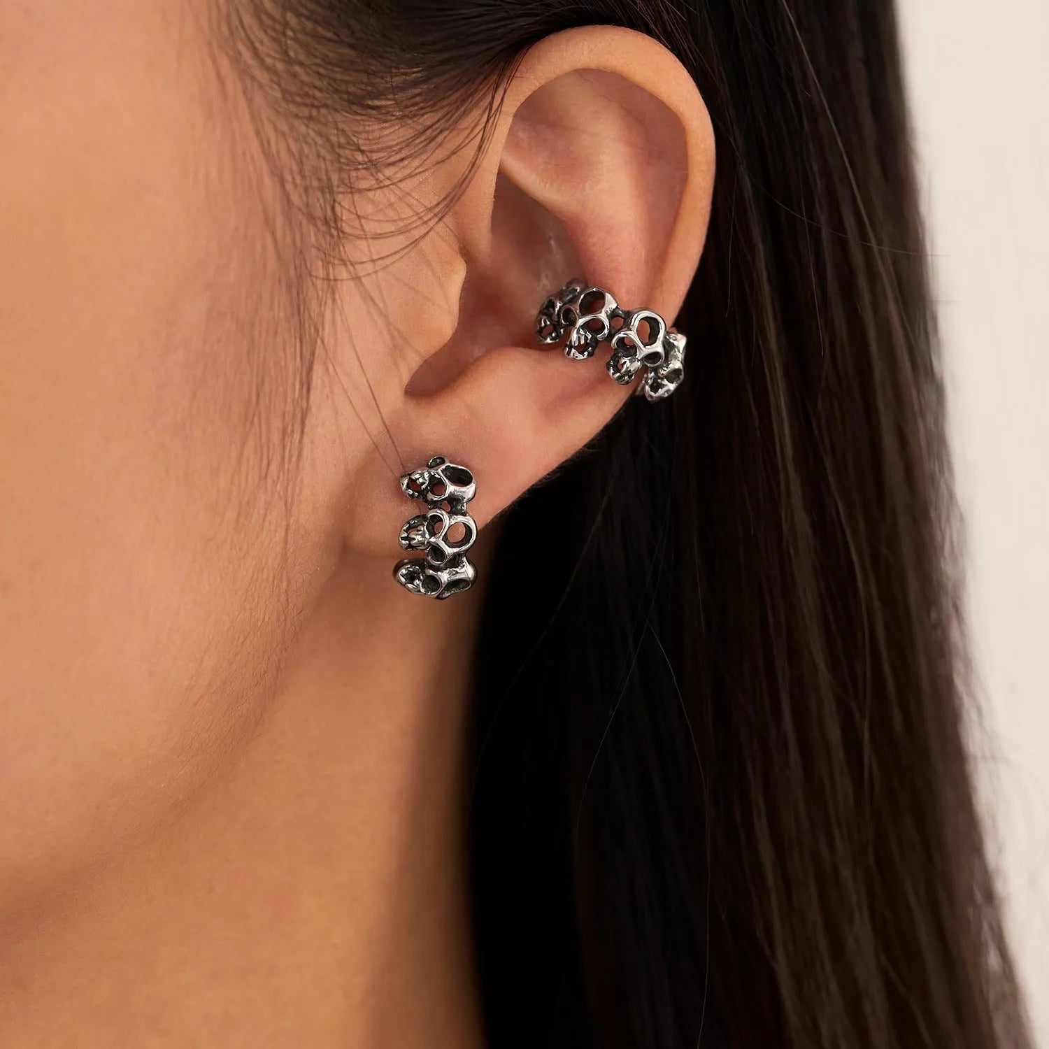 Stainless steel hollow skull ear clips with geometric design and metallic finish