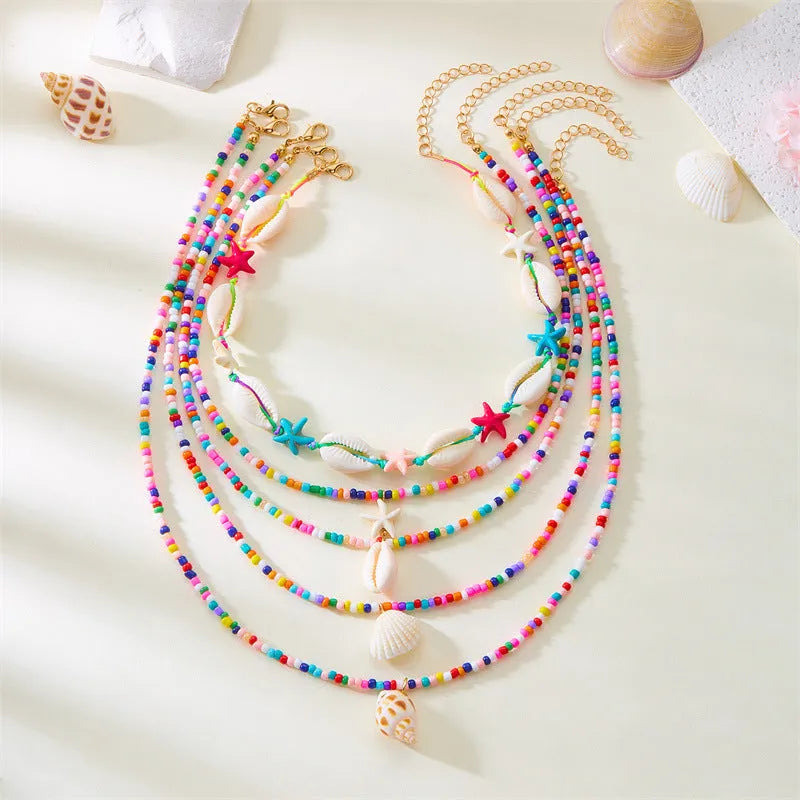 Five-piece women's necklace set with starfish, shell and conch bead pendants on adjustable chains