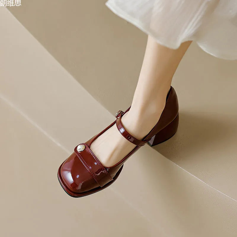 Women's apricot patent leather heel pumps with a chunky block heel and buckle fastening