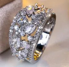 Women's hollow round fashion ring in gold or platinum with a choice of white or blue gemstone.