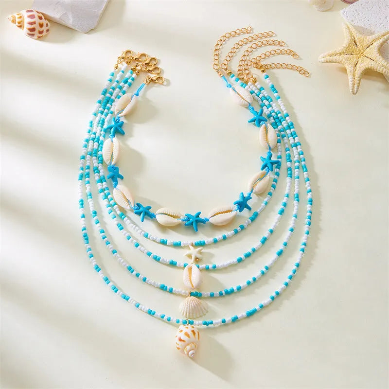 Five-piece women's necklace set with starfish, shell and conch bead pendants on adjustable chains