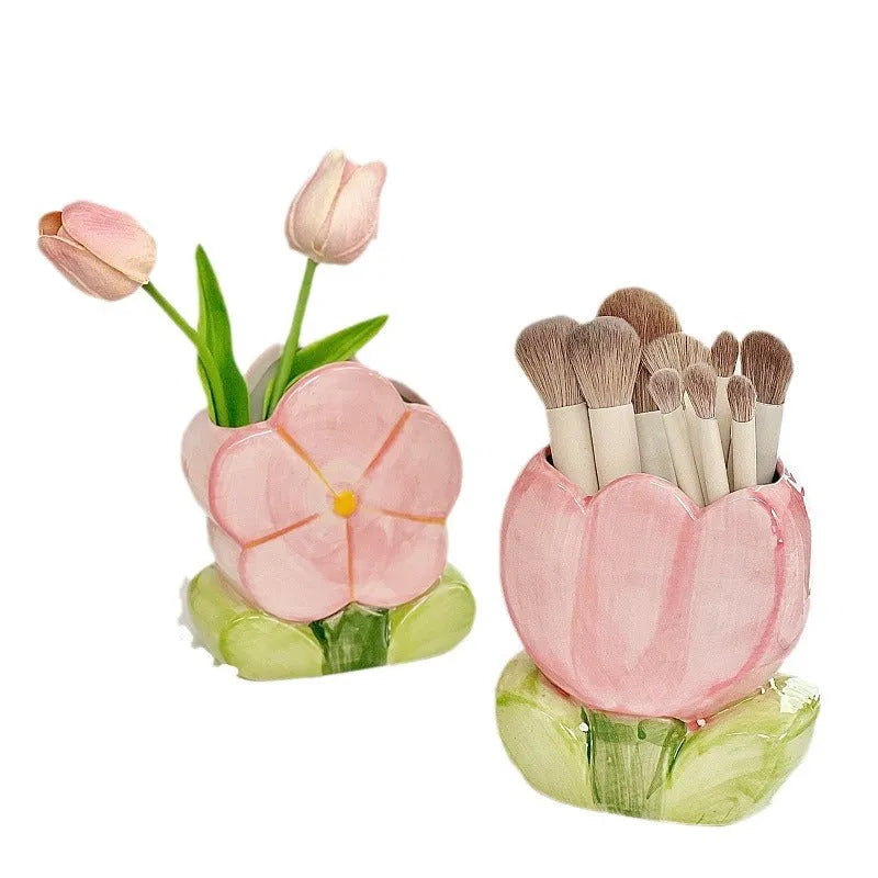 Ceramic pen holder box with floral pattern and lid on a wooden desk.