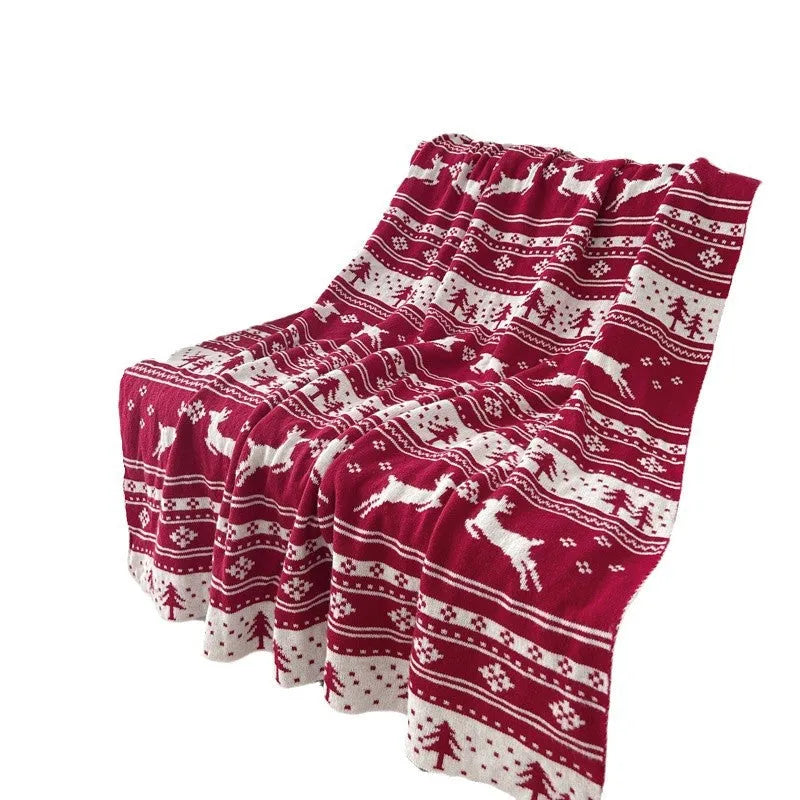 Personalised Christmas acrylic blanket with reindeer or snowflake pattern on a sofa
