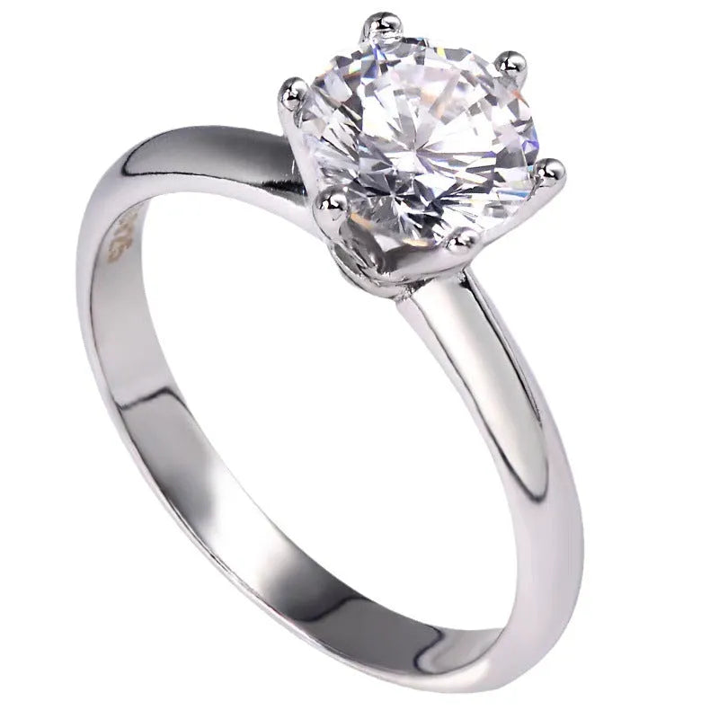 White gold plated geometric women's ring with a six-claw zircon setting, shown on a hand.