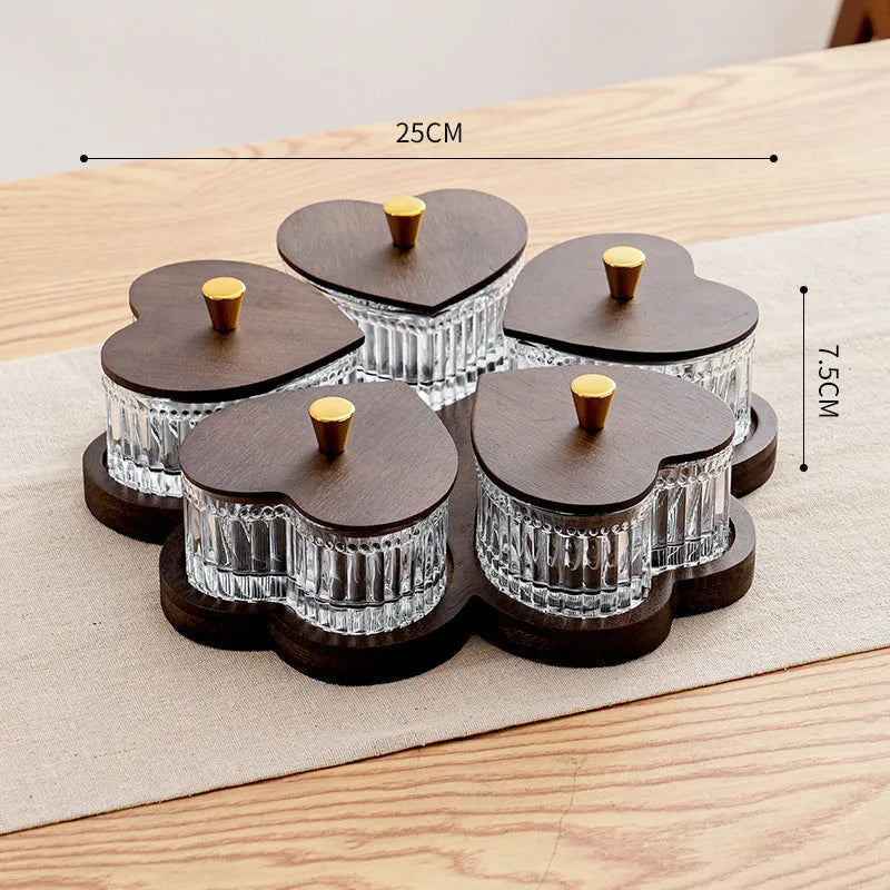 Glass fruit platter with transparent heart-shaped lids covering compartmentalised snack trays in retro design