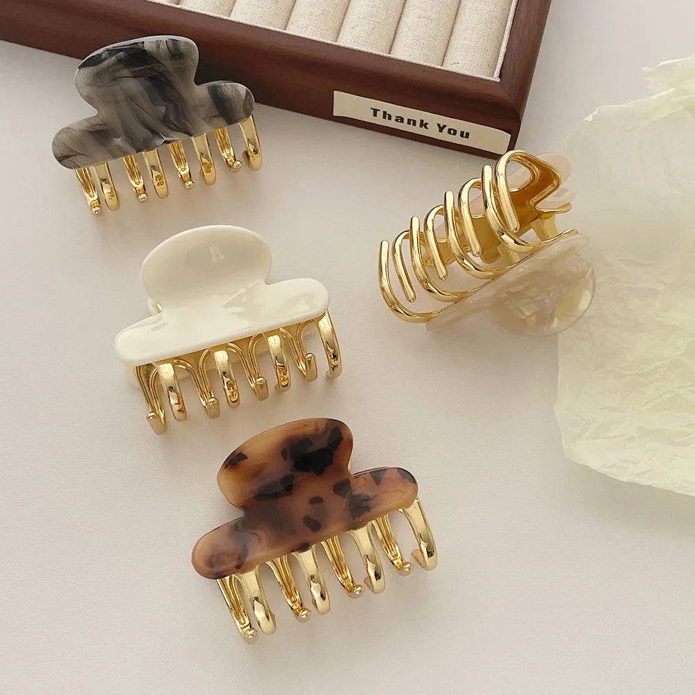 Medium metal grip acetate hair barrettes in four colours: fairy white, leopard print, creamy-white, and ink colour