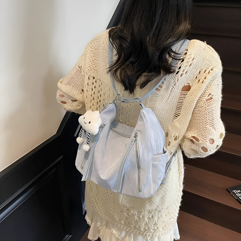 Soft black PU leather women's backpack shown with detachable pendant accessory.