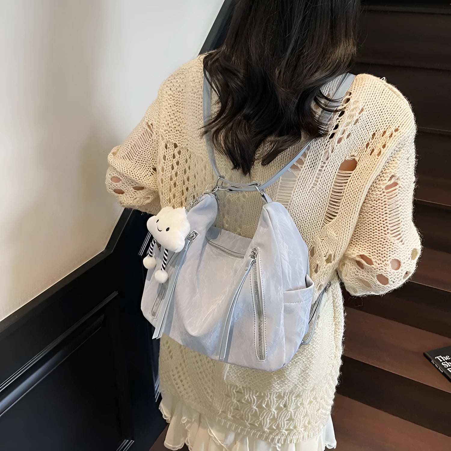 Soft black PU leather women's backpack shown with detachable pendant accessory.