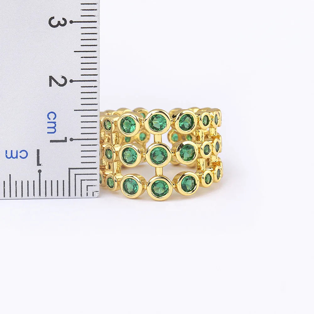 Gold plated copper ring with three green zircon stones in layered arrangement on wide band