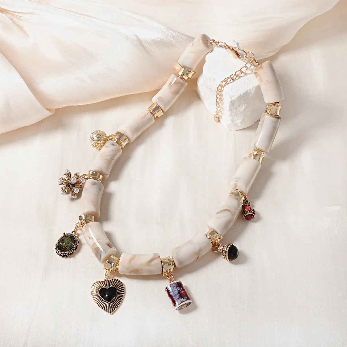 Gold-plated chain necklace with a white heart-shaped resin bamboo pendant.