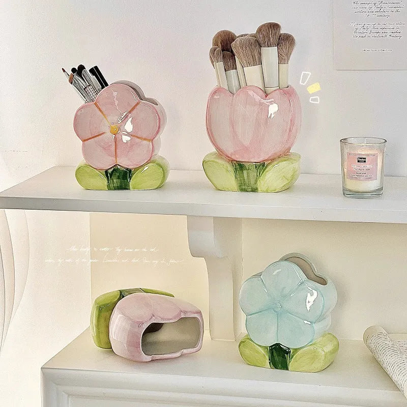 Ceramic pen holder box with floral pattern and lid on a wooden desk.