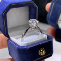 White gold plated geometric women's ring with a six-claw zircon setting, shown on a hand.