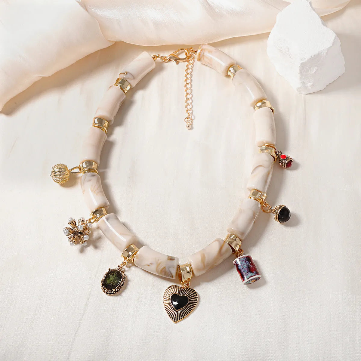 Gold-plated chain necklace with a white heart-shaped resin bamboo pendant.