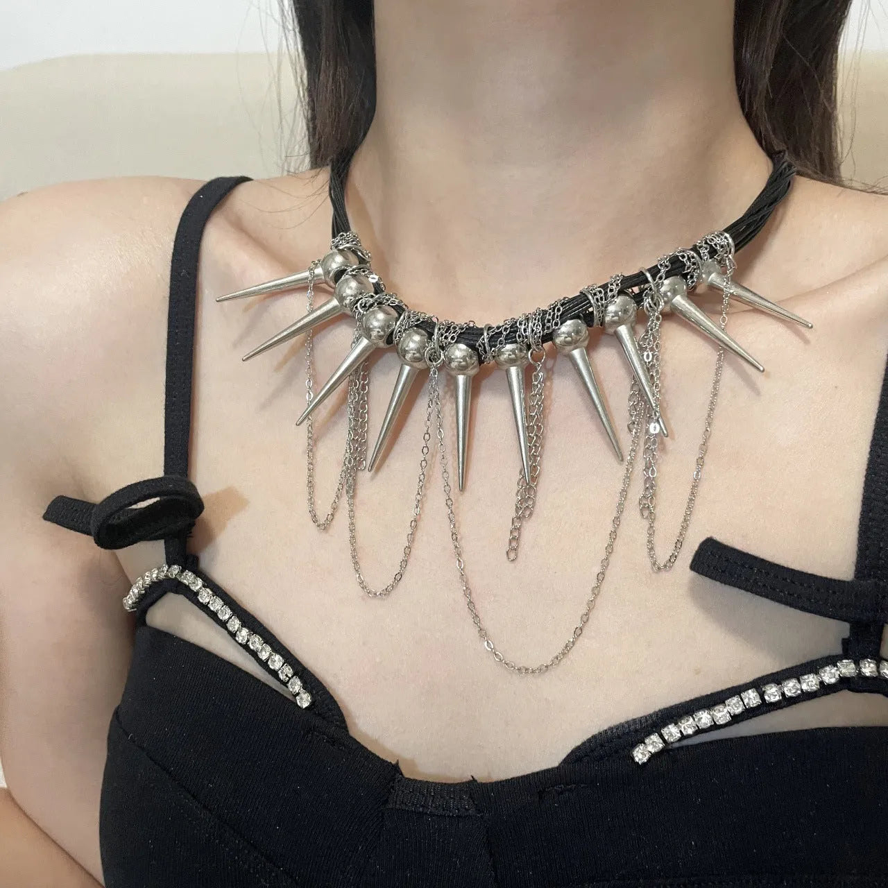 Women's leather necklace with round beads, a winding tassel, and metallic point rivets.