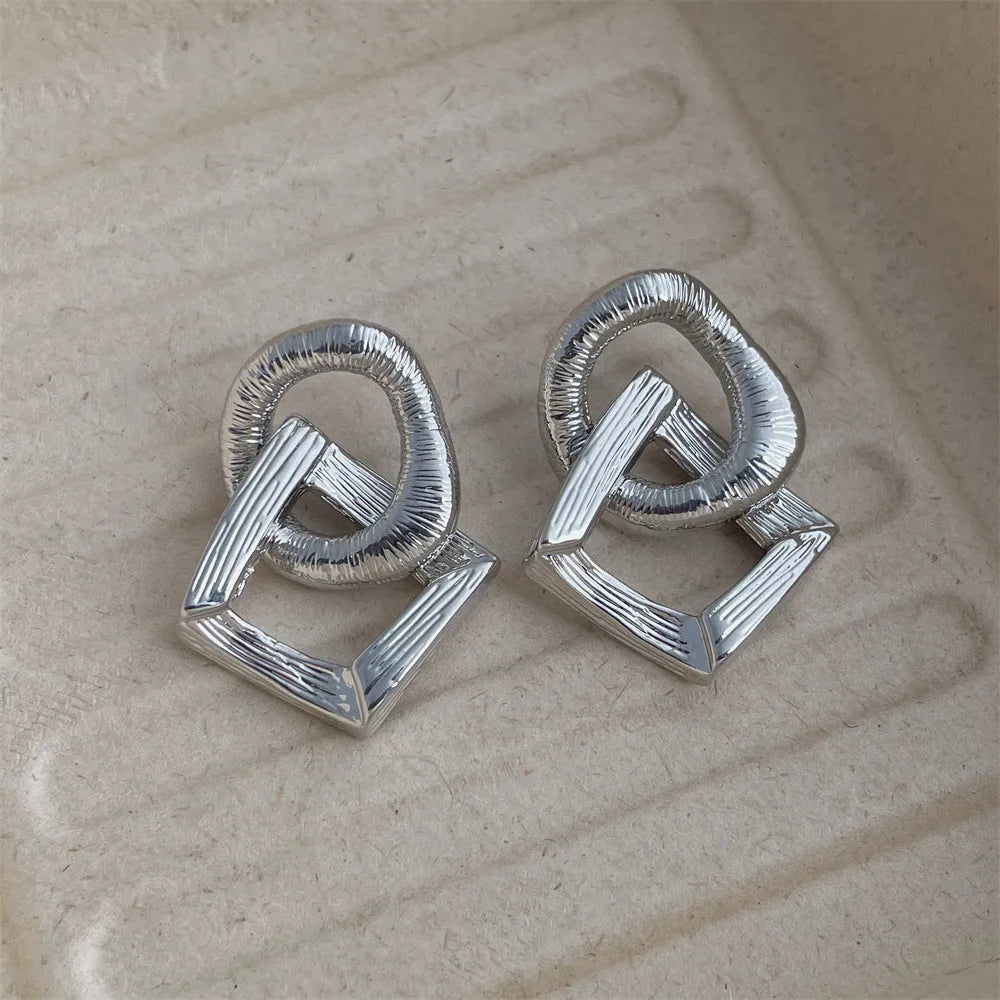 Geometric circle pendant drop earrings in gold or silver tone with a 3.4cm length.