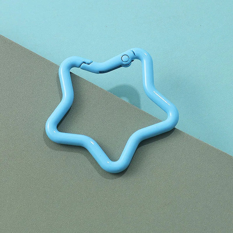 Zinc alloy five-pointed star keychain in light pink colour on a white background.