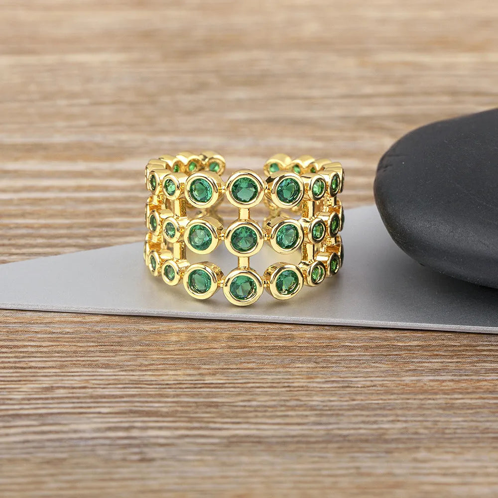 Gold plated copper ring with three green zircon stones in layered arrangement on wide band