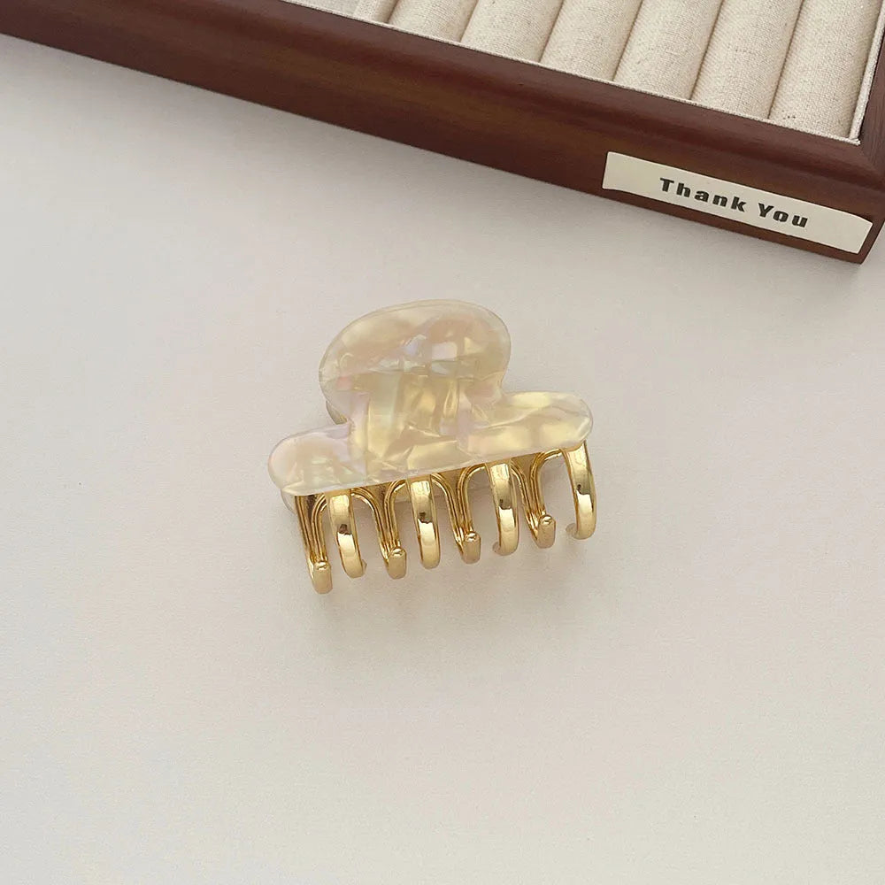 Medium metal grip acetate hair barrettes in four colours: fairy white, leopard print, creamy-white, and ink colour