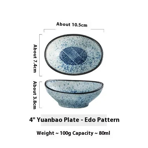 Oval Japanese ceramic dipping bowl with underglaze pattern on a wooden table.