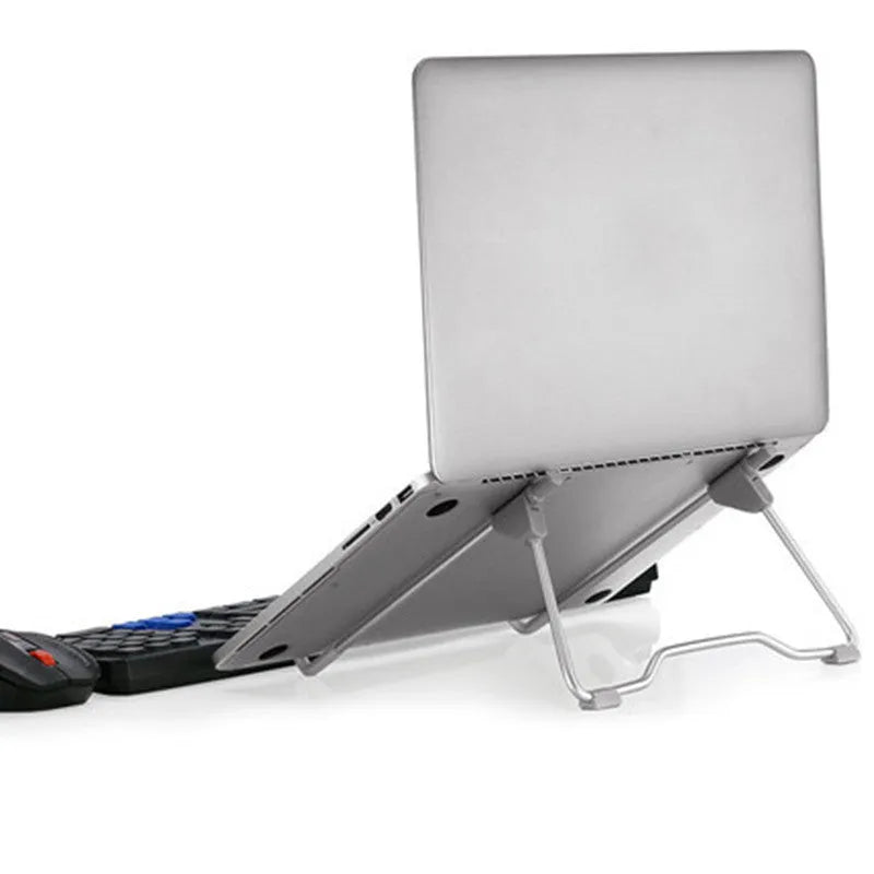 Grey aluminium alloy and plastic stand holding a mobile phone and a laptop on a desk.