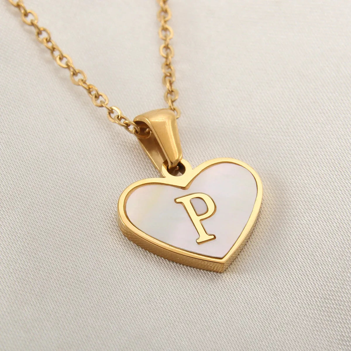 Gold heart necklace with white shell detail and personalised initial letter on adjustable chain