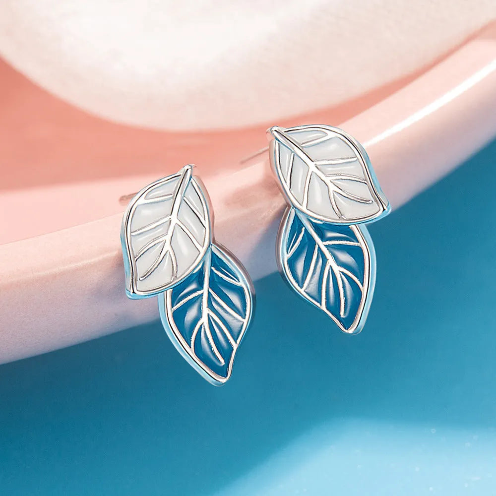 White gold plated copper leaf-shaped stud earrings for women on white background