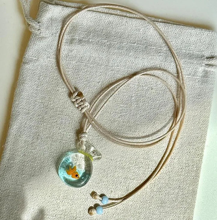 Women's necklace with coloured glaze joker charm on cotton linen chain in small fish lucky bag colour