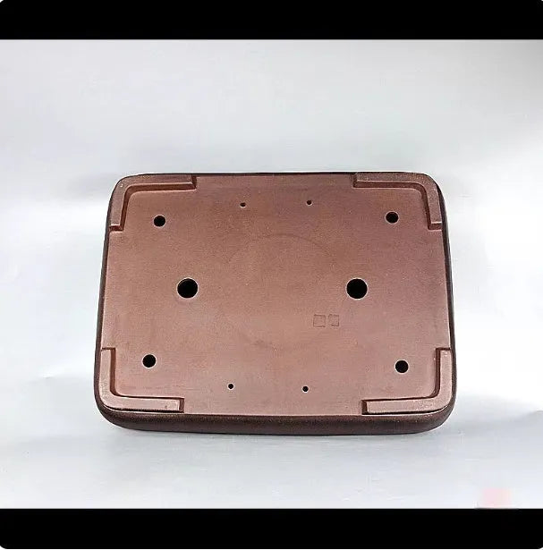 Handmade antique-style rectangular purple clay flower pot on a wooden surface.