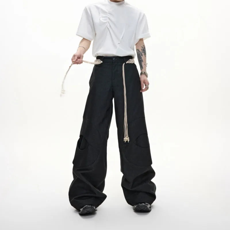 Men's dark blue straight-leg cotton jeans with 3D cutting, belt stitching, and decorative pocket tassels.