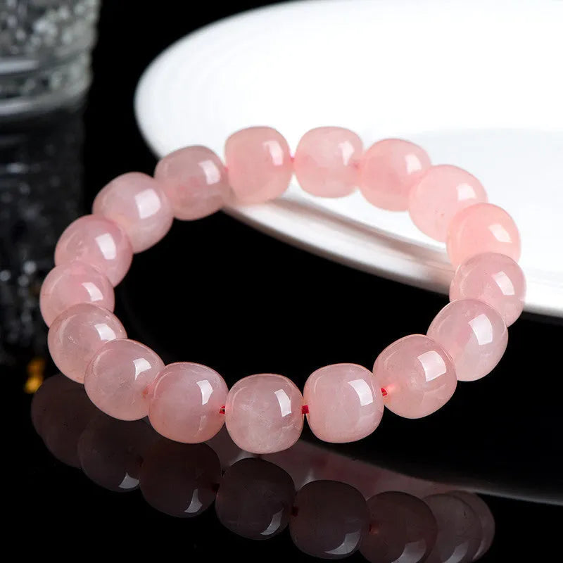 Pink crystal barrel bead stretch bracelet with 8-10mm polished beads on a wrist.