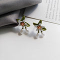 Two pairs of women's floral alloy earrings: one clip-on flower style and one pair of sterling silver needle flower studs.