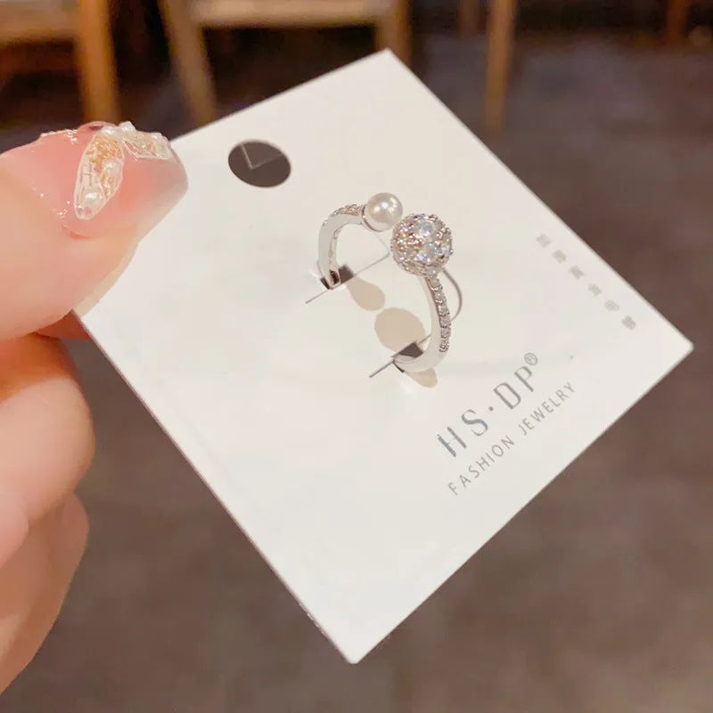 Gold plated open-end ring with round zircon pearl element on copper base