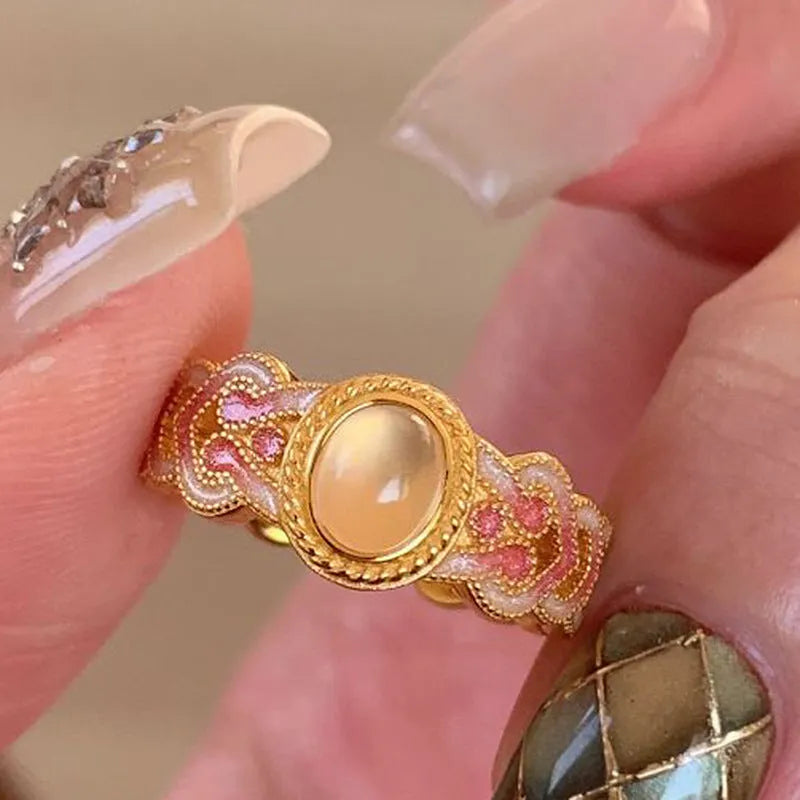 Geometric open ring for women with pink crystal enamel detail on a gold-plated copper band.