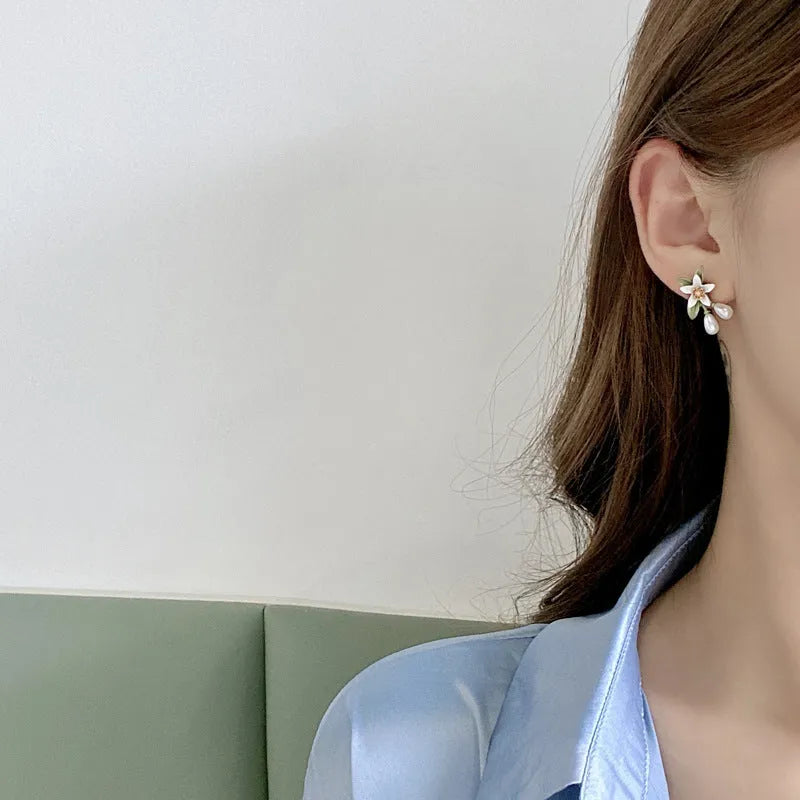 Two pairs of women's floral alloy earrings: one clip-on flower style and one pair of sterling silver needle flower studs.