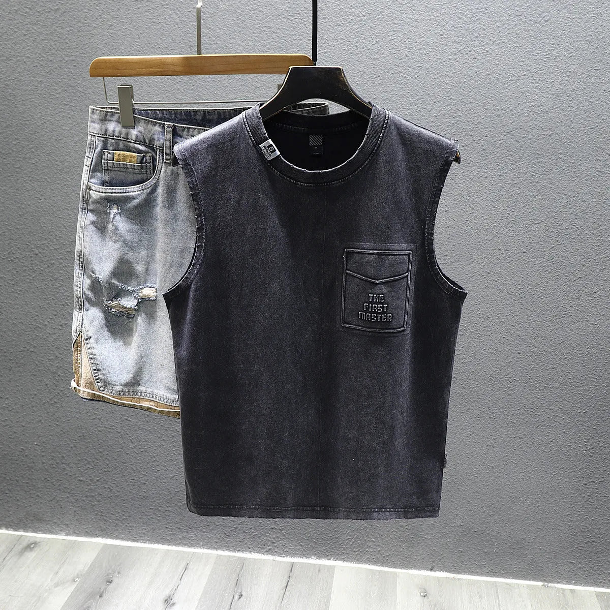 Women's loose-fit black cotton sleeveless t-shirt with straight hem on a hanger.