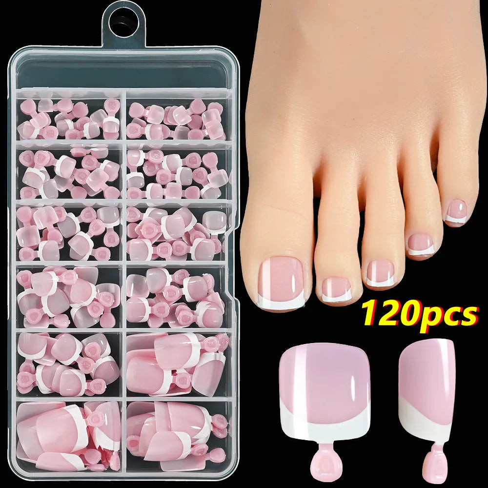 Box of 120 French white edge nude false toe nail pieces in assorted shades on a table