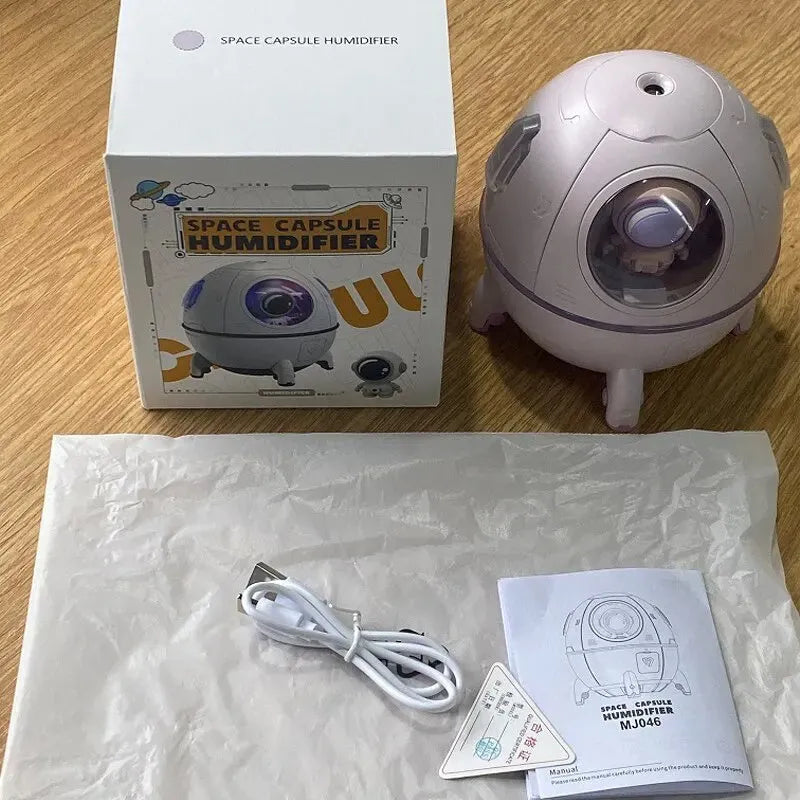 Light purple astronaut capsule-shaped portable USB humidifier on a desk