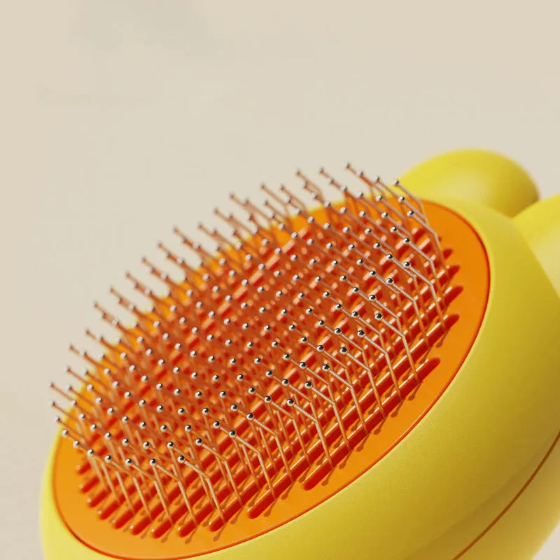 Self-cleaning pet grooming brush with green handle and stainless steel comb, showing the one-click release button.