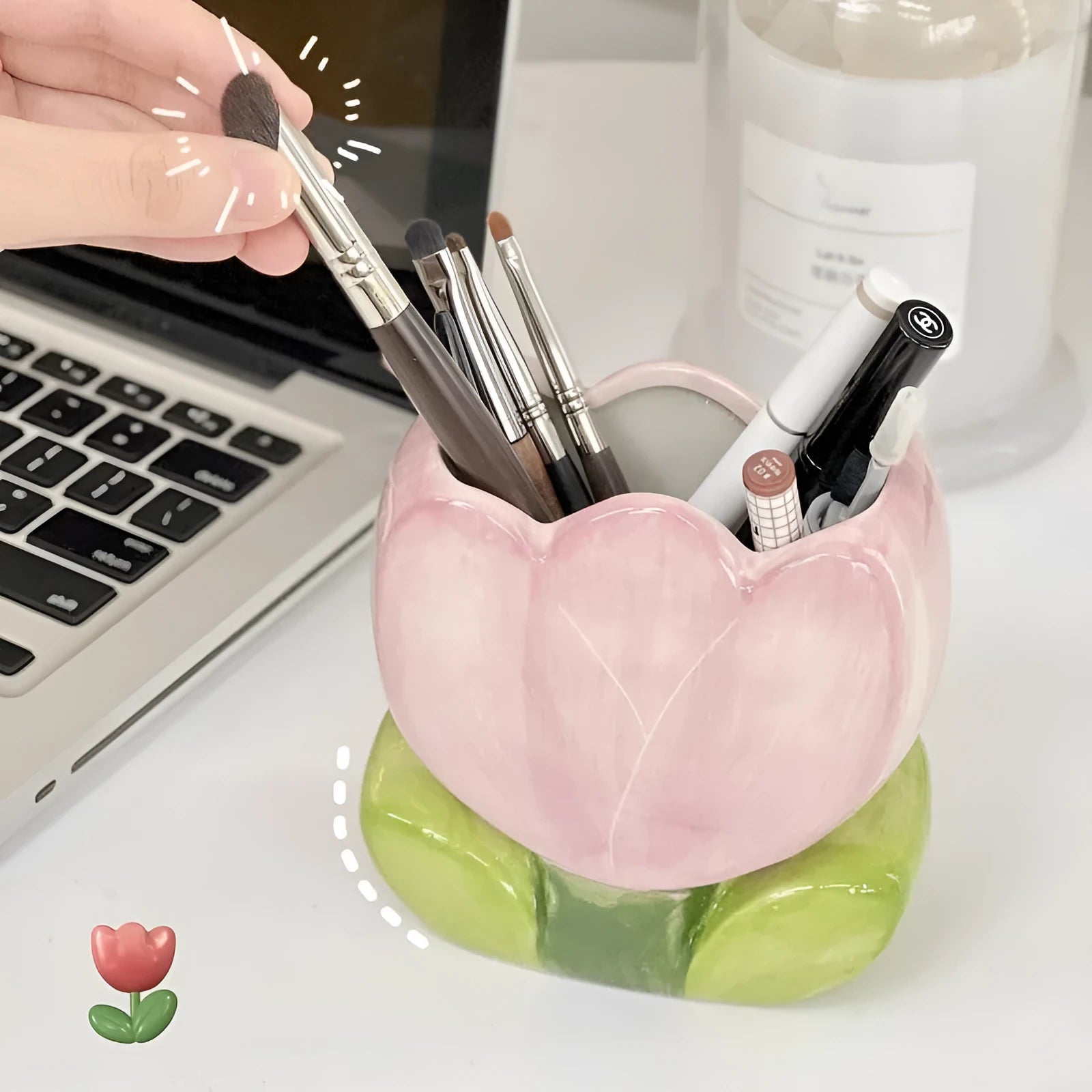 Ceramic pen holder box with floral pattern and lid on a wooden desk.