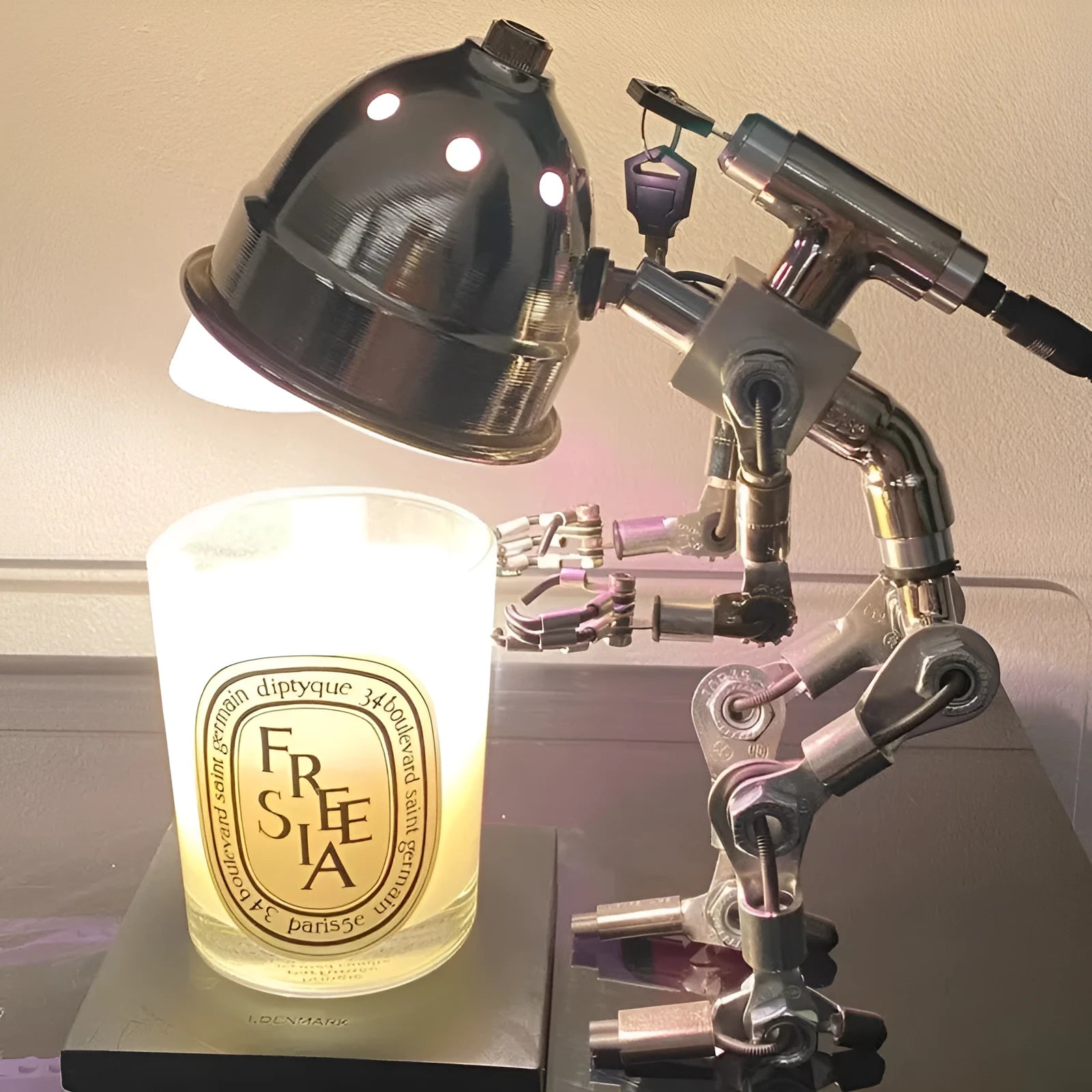 Silver copper robot-shaped atmosphere light with graphic customisation on a desk.