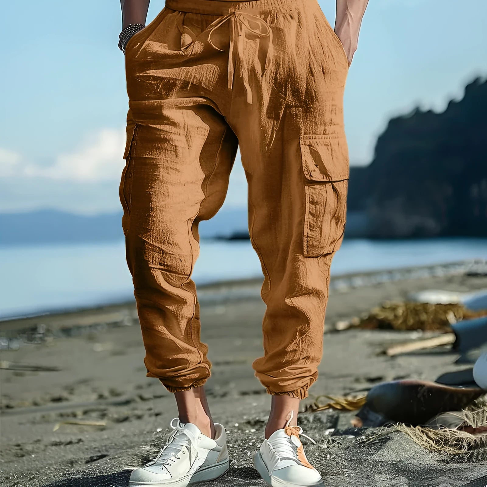 Man wearing loose-fit linen casual trousers with ankle-tied cuffs and multiple pockets in a solid colour.
