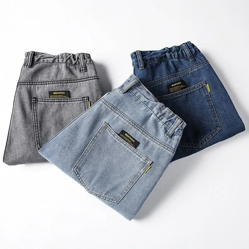 Man wearing dark blue loose straight-cut cotton jeans with a mid-waist and zipper fly.