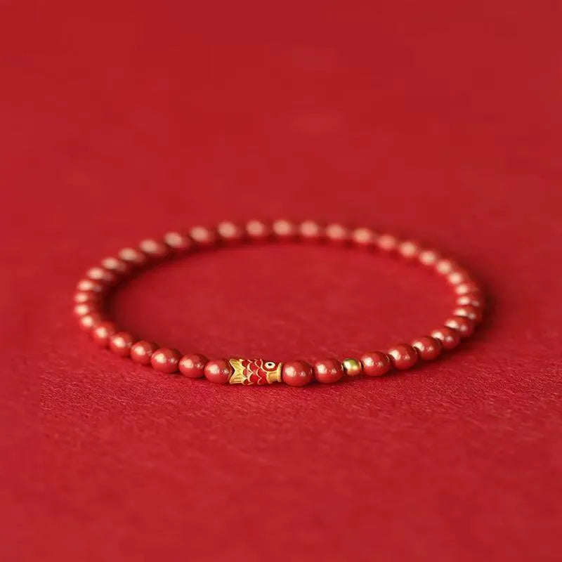 Natural cinnabar koi carp bracelet with gold ball in 4mm or 6mm size on wrist.
